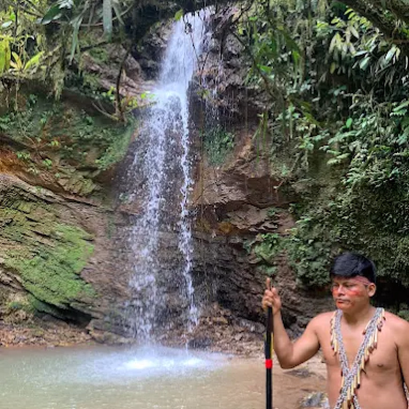 persona de la cultura shuar junto a una cascada