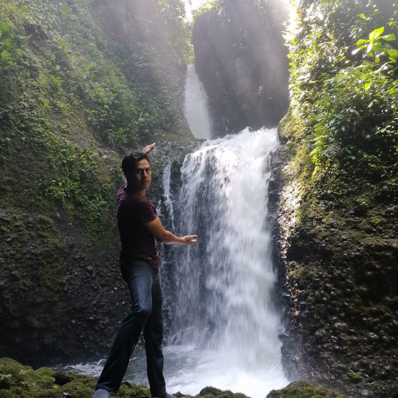 Turista en frente de la cascada